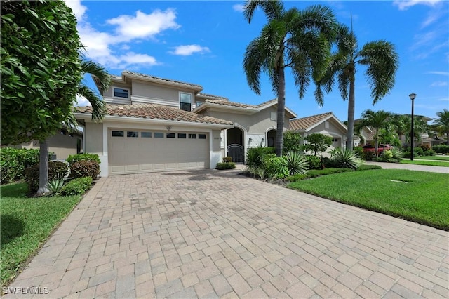 mediterranean / spanish house featuring a garage and a front lawn