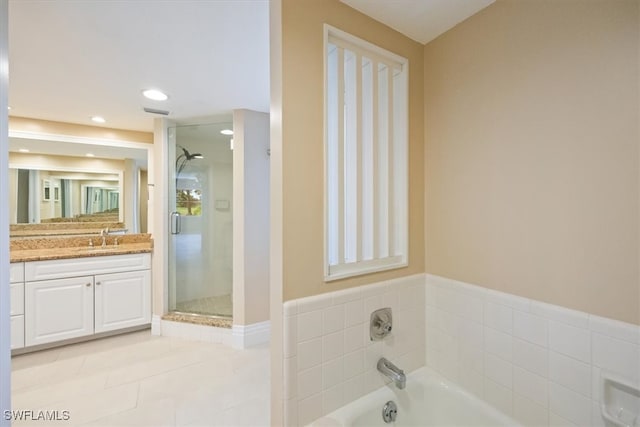 bathroom with plus walk in shower, tile patterned flooring, and vanity