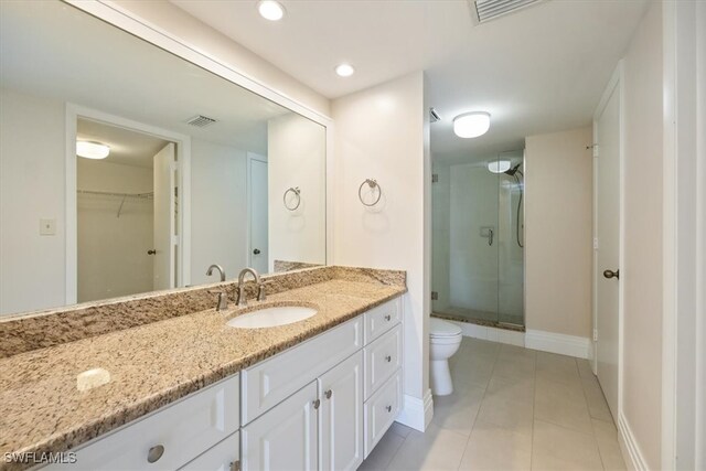 bathroom featuring vanity, toilet, tile patterned floors, and a shower with door