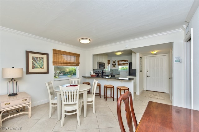 tiled dining room with a textured ceiling and crown molding