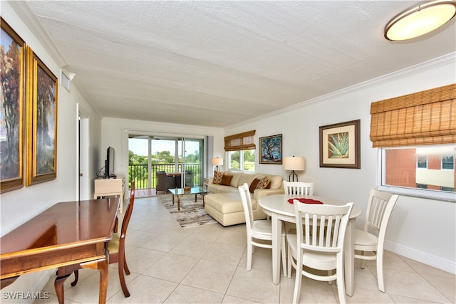 dining room featuring light tile patterned floors, a textured ceiling, and ornamental molding