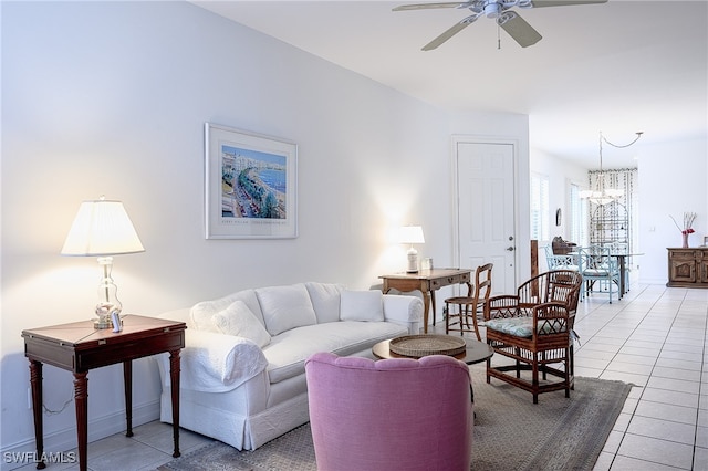 living room featuring ceiling fan with notable chandelier and light tile patterned floors