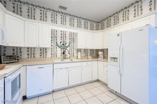 kitchen with white appliances, white cabinetry, sink, and light tile patterned flooring