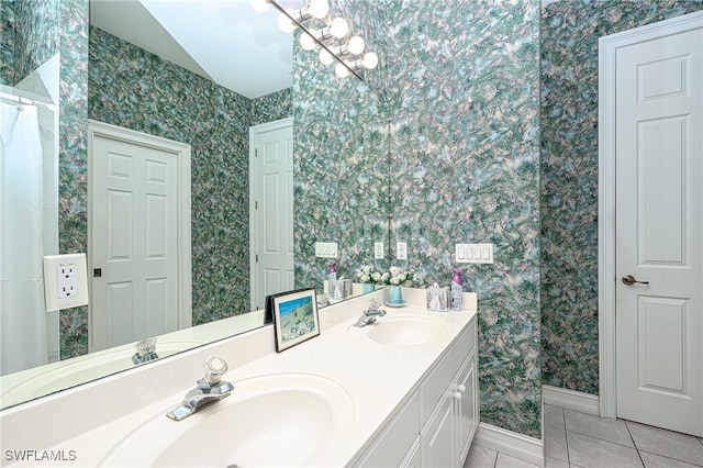 bathroom with an inviting chandelier, tile patterned floors, and vanity