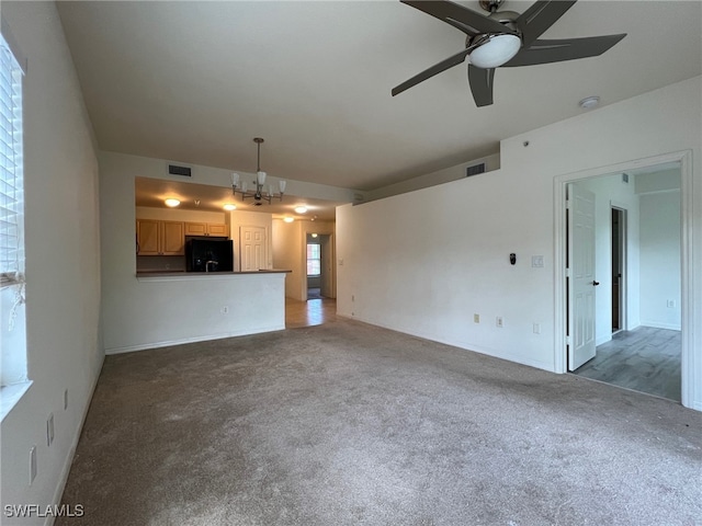 unfurnished living room with dark carpet and ceiling fan with notable chandelier