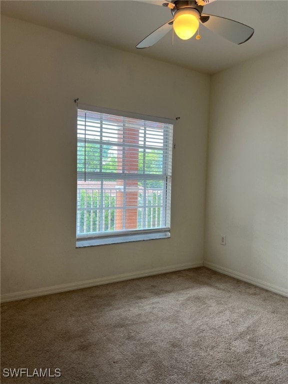 carpeted spare room with ceiling fan