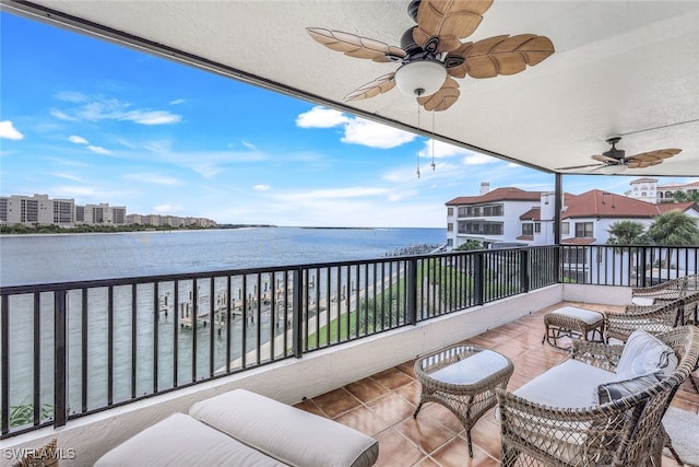 balcony with a water view and ceiling fan