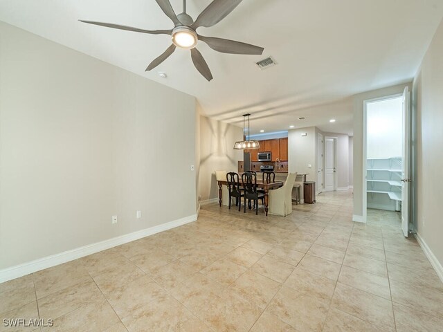 interior space with light tile patterned flooring and ceiling fan with notable chandelier