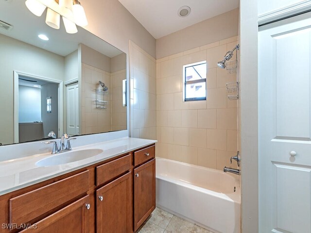 bathroom with tiled shower / bath, vanity, and tile patterned flooring