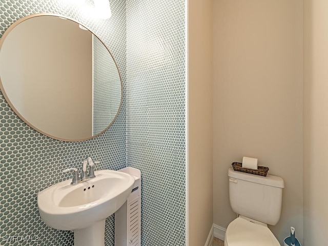 half bathroom featuring a sink and toilet