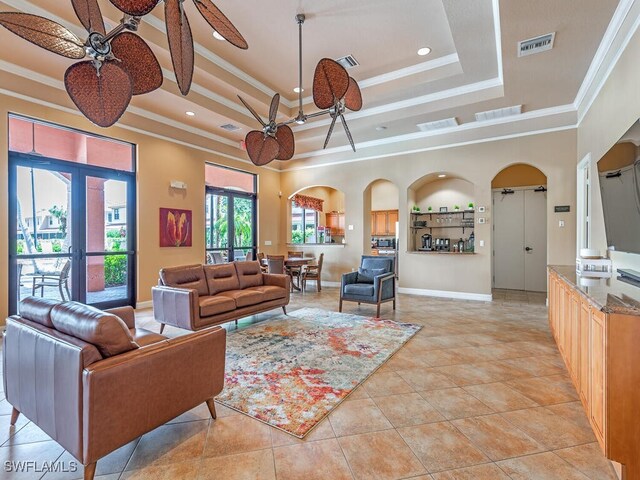 tiled living room with ornamental molding and ceiling fan