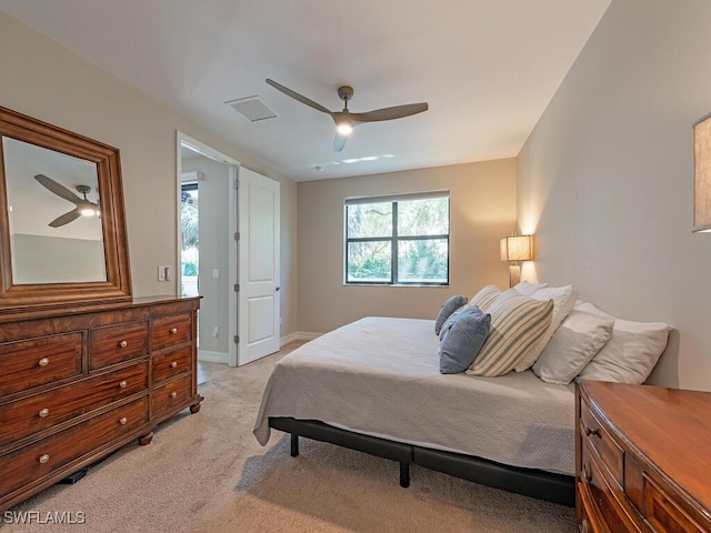 bedroom featuring visible vents, a ceiling fan, baseboards, and light carpet