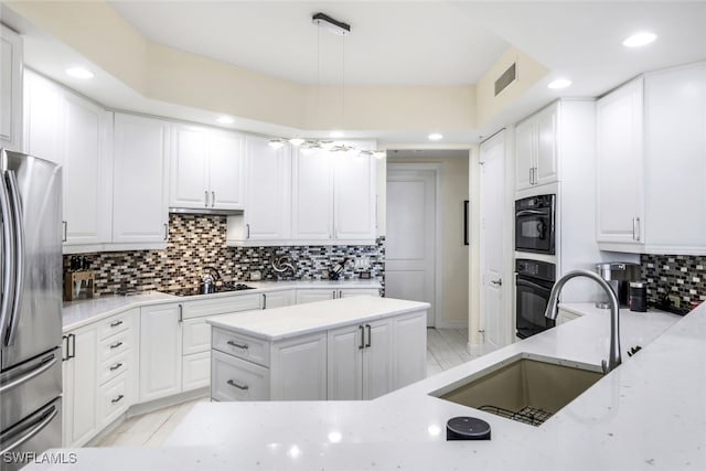 kitchen featuring hanging light fixtures, white cabinetry, sink, and black appliances