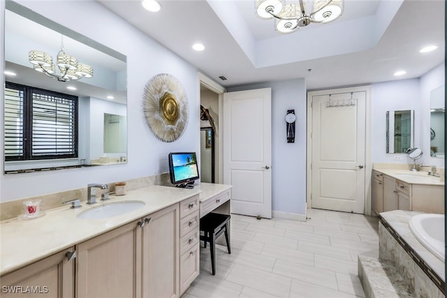 bathroom with an inviting chandelier, vanity, and tiled bath