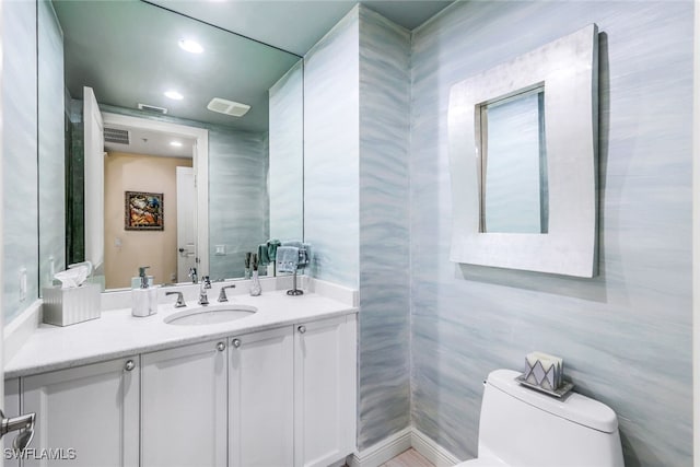 bathroom with vanity, tile walls, and toilet