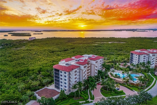 aerial view at dusk featuring a water view