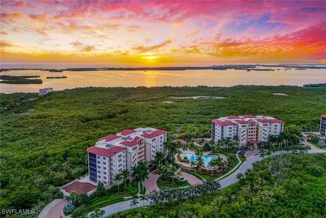 aerial view at dusk featuring a water view