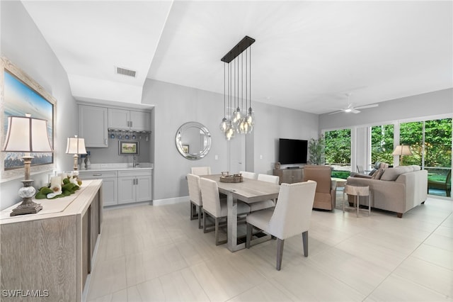 dining room featuring light tile patterned flooring and ceiling fan with notable chandelier