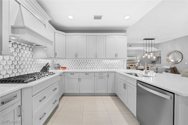 kitchen featuring sink, tasteful backsplash, white cabinetry, stainless steel appliances, and custom range hood