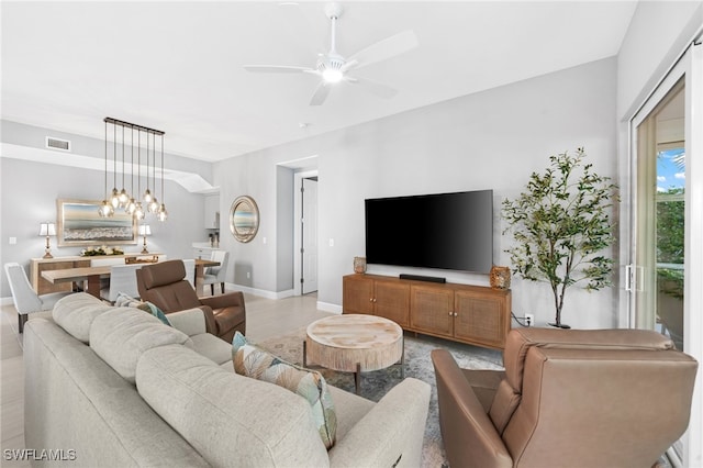 living room featuring ceiling fan with notable chandelier