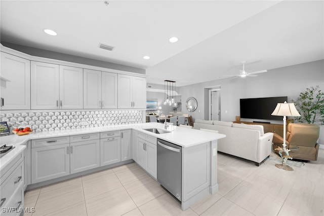 kitchen with dishwasher, sink, ceiling fan with notable chandelier, kitchen peninsula, and hanging light fixtures