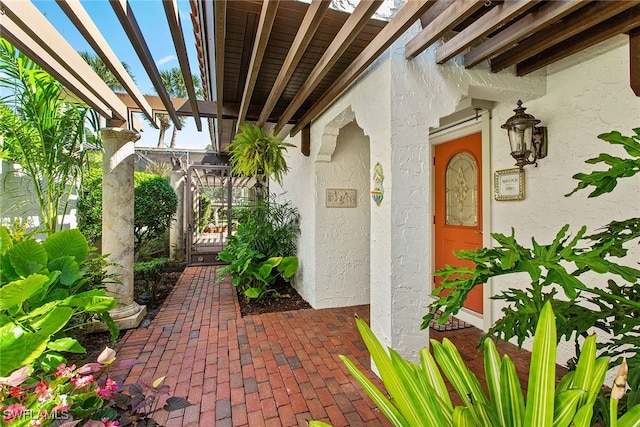 view of exterior entry featuring a pergola