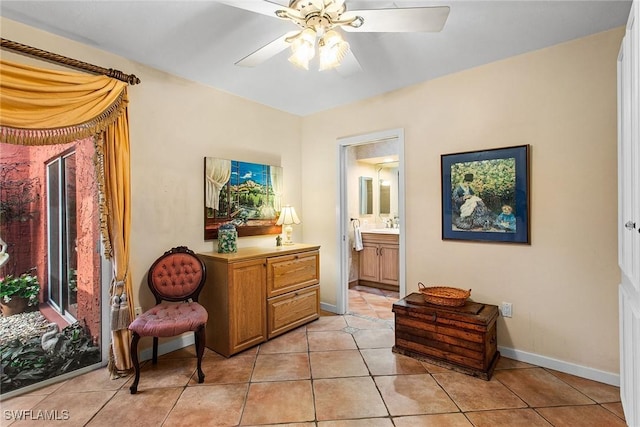 living area featuring light tile patterned floors, baseboards, and ceiling fan