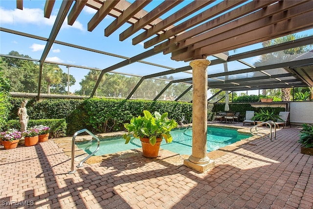 view of pool with glass enclosure and a patio area