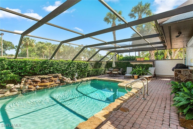 view of swimming pool featuring glass enclosure and a patio area