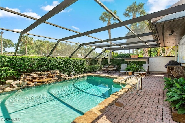 outdoor pool with glass enclosure and a patio