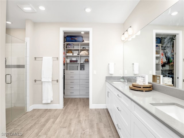 bathroom featuring vanity, hardwood / wood-style floors, and a shower with door