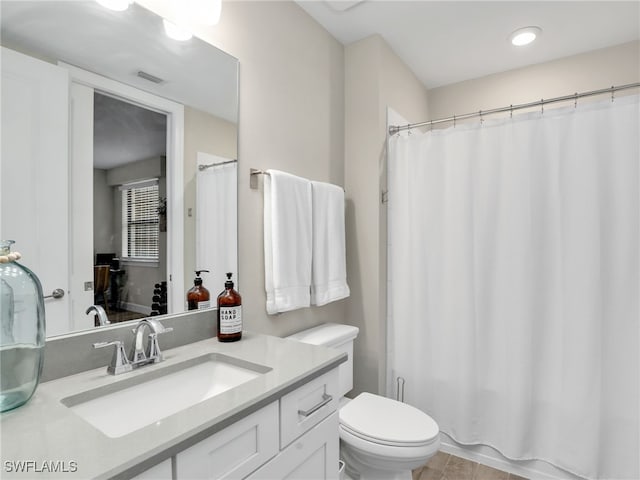 bathroom featuring tile patterned floors, walk in shower, toilet, and vanity