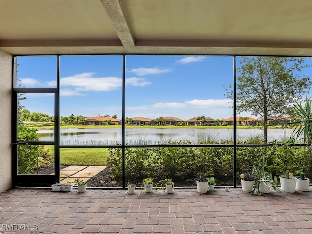 unfurnished sunroom featuring a water view