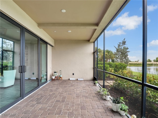 unfurnished sunroom with a healthy amount of sunlight and a water view