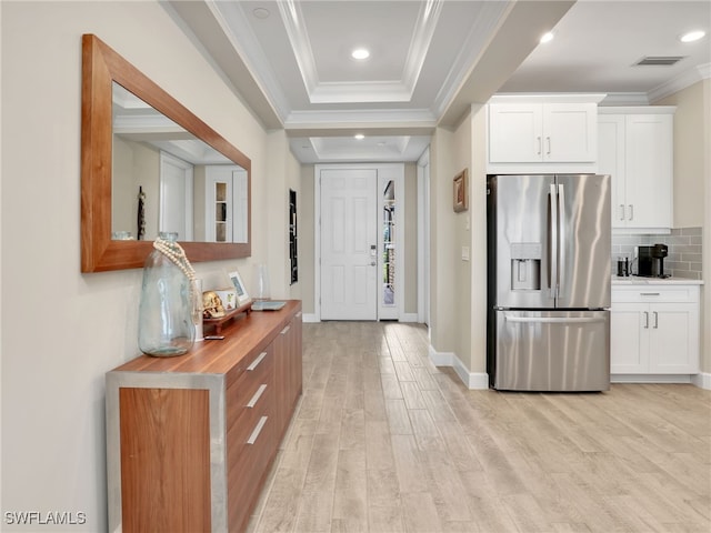 kitchen featuring light wood-type flooring, stainless steel fridge, butcher block countertops, and white cabinetry