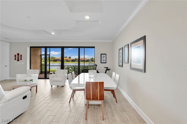 dining area featuring a raised ceiling, ornamental molding, and light hardwood / wood-style floors