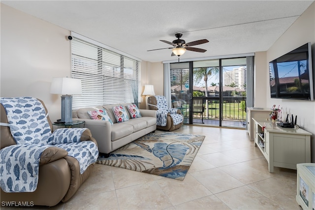 living room featuring ceiling fan, light tile patterned floors, and a textured ceiling