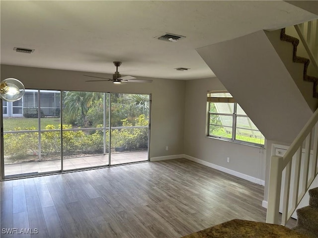 unfurnished living room featuring hardwood / wood-style floors, a wealth of natural light, and ceiling fan