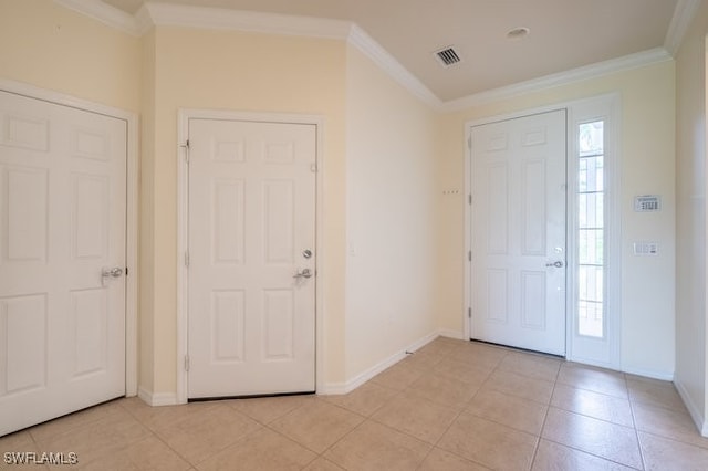 foyer with crown molding and light tile patterned floors