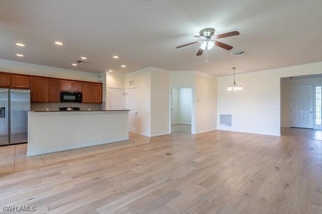 kitchen with a center island, ceiling fan with notable chandelier, light hardwood / wood-style flooring, black appliances, and decorative light fixtures