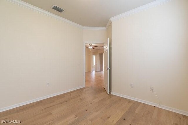 spare room featuring ornamental molding, light wood-type flooring, and ceiling fan