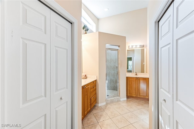 bathroom with tile patterned floors, a shower with door, and vanity