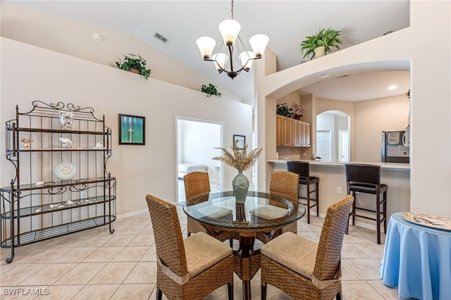 dining area featuring an inviting chandelier, light tile patterned floors, and high vaulted ceiling