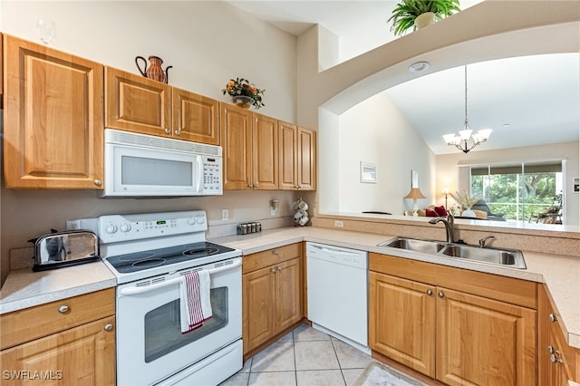 kitchen featuring light tile patterned flooring, sink, a notable chandelier, hanging light fixtures, and white appliances