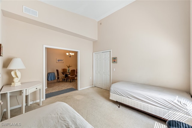 carpeted bedroom featuring an inviting chandelier and a closet