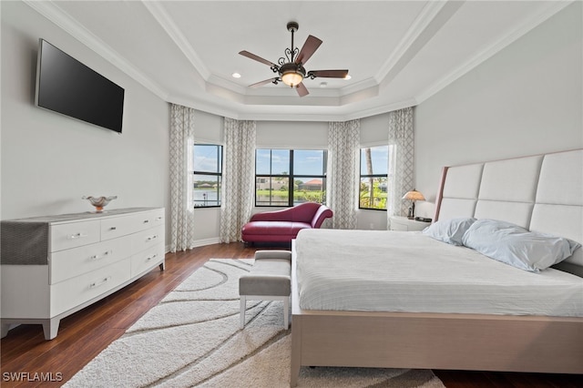 bedroom featuring ceiling fan, a tray ceiling, crown molding, and dark hardwood / wood-style flooring