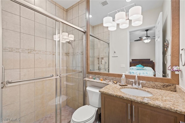 bathroom featuring walk in shower, vanity, toilet, and ceiling fan