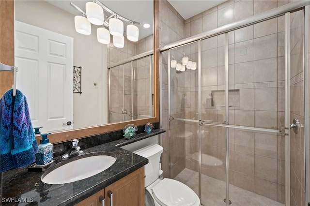 bathroom with vanity, toilet, and a shower with shower door