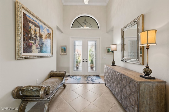 entrance foyer featuring ornamental molding, light tile patterned flooring, and french doors