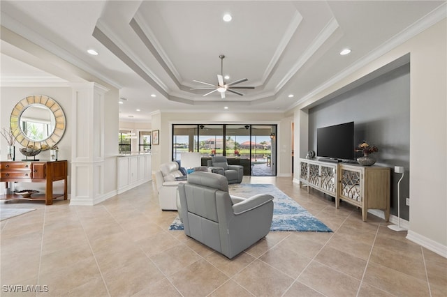 living room with ceiling fan, light tile patterned floors, a raised ceiling, and ornamental molding